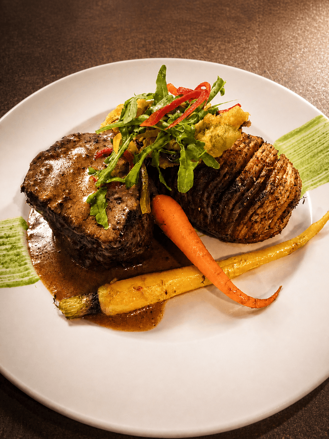A grilled lamb chop with charred vegetables and a bright herb salad.