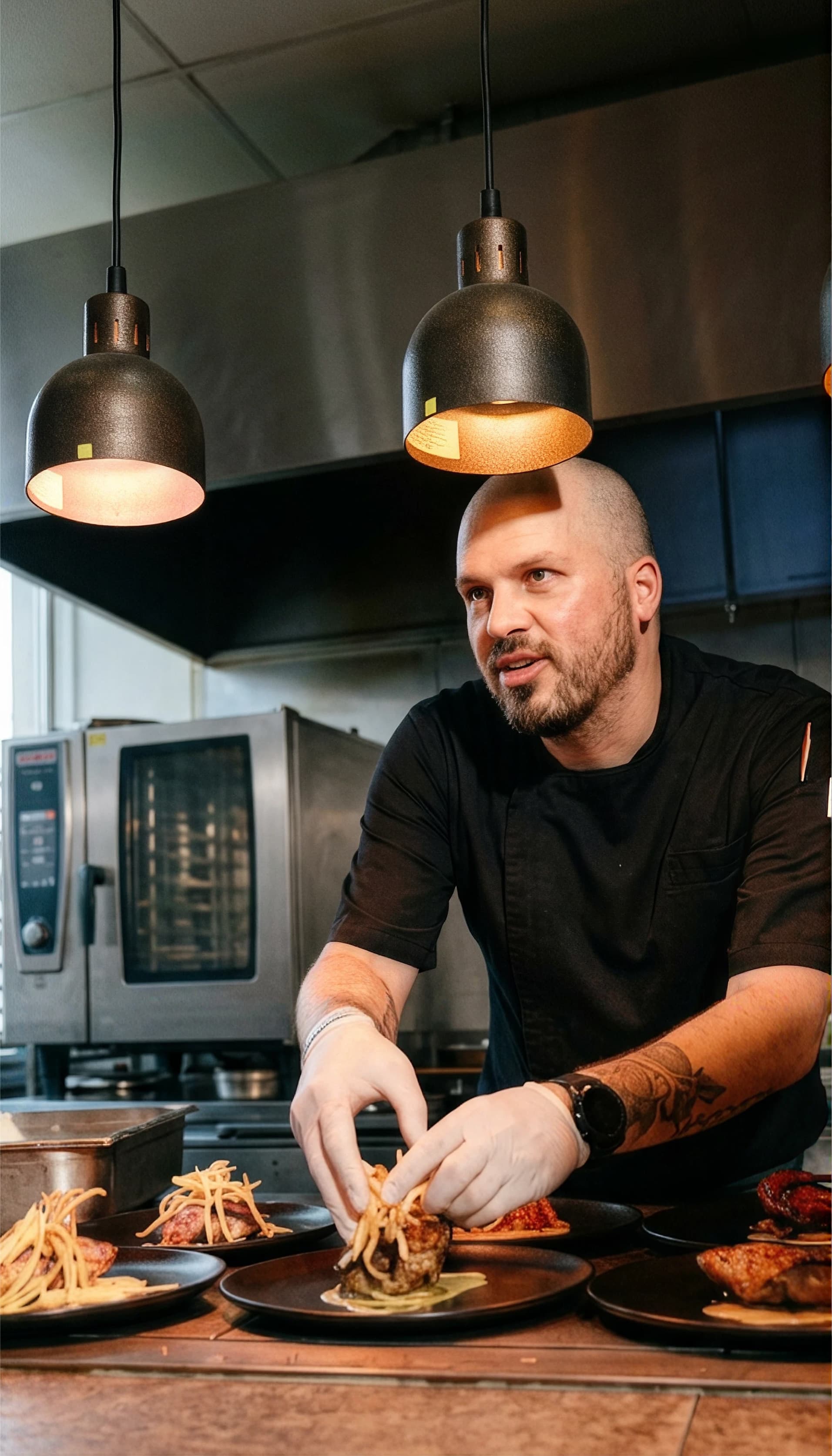Chef Tristan plating dishes at the pass in his kitchen.