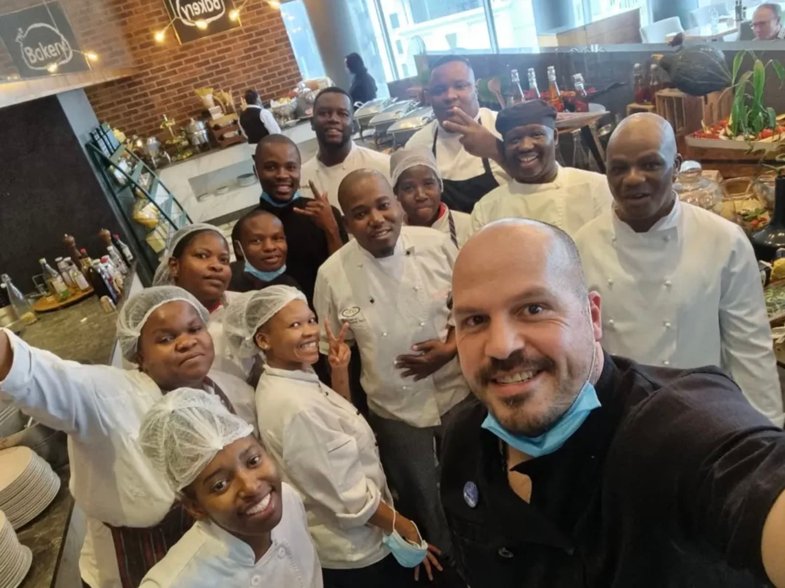 Chef Tristan with his kitchen and front-of-house team in a hotel buffet restaurant.